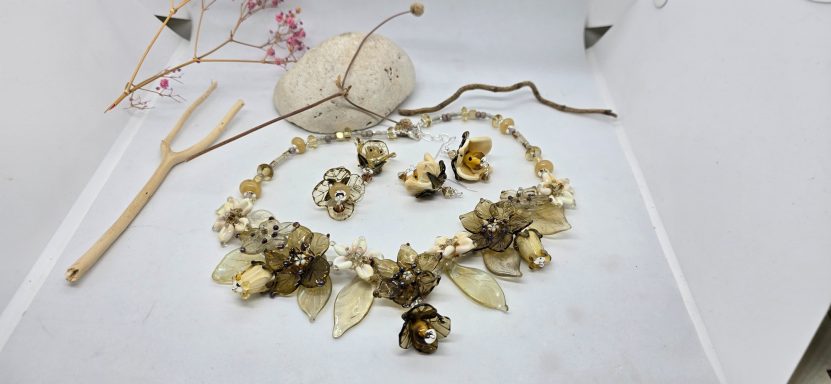 Schmuckarrangements aus Naturmaterialien, darunter eine Halskette und Ohrringe.